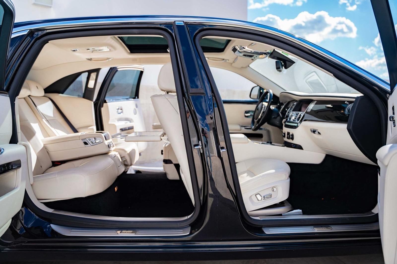 Rolls-Royce interior with white leather seats and open doors